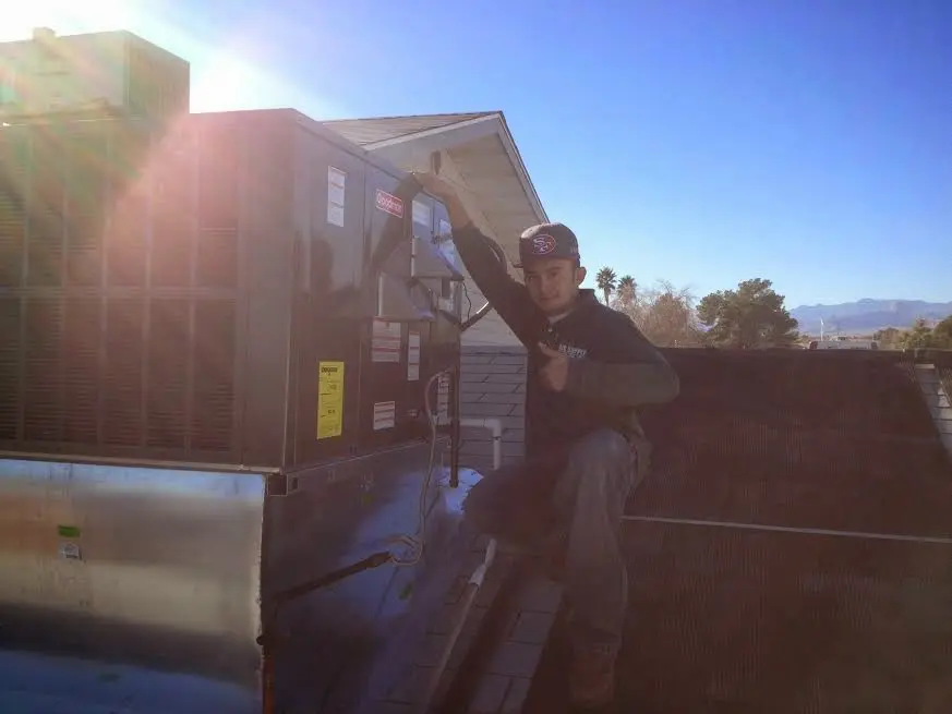 HVAC technician performing Air Duct Repair on a rooftop unit in East Palo Alto